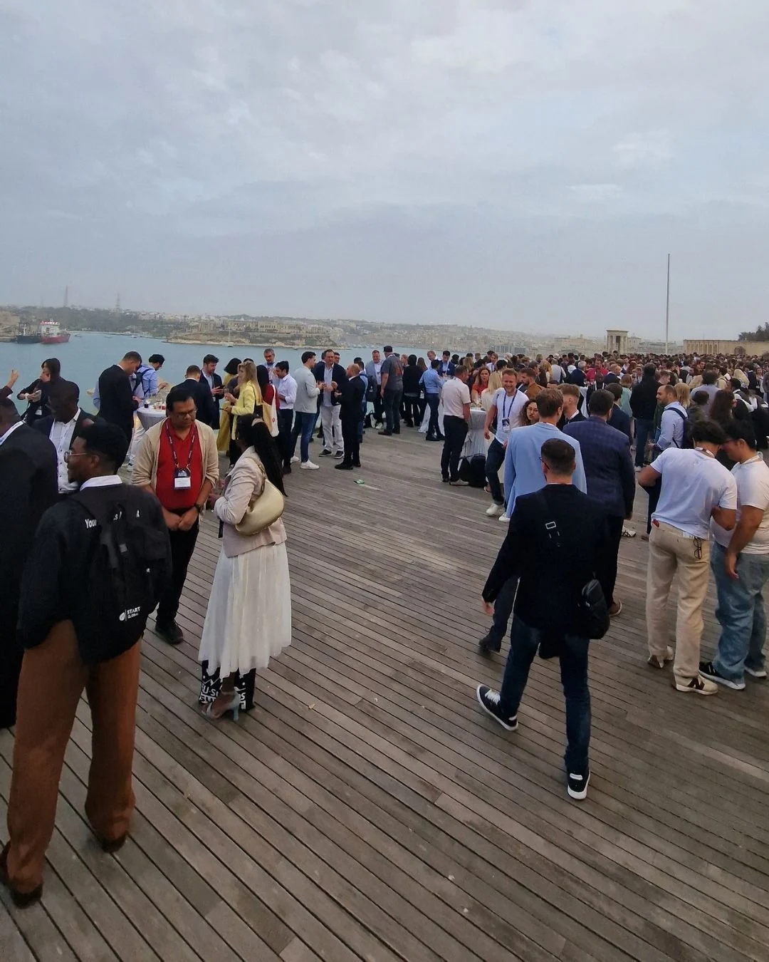 Summit attendees networking by the waterfront in Malta