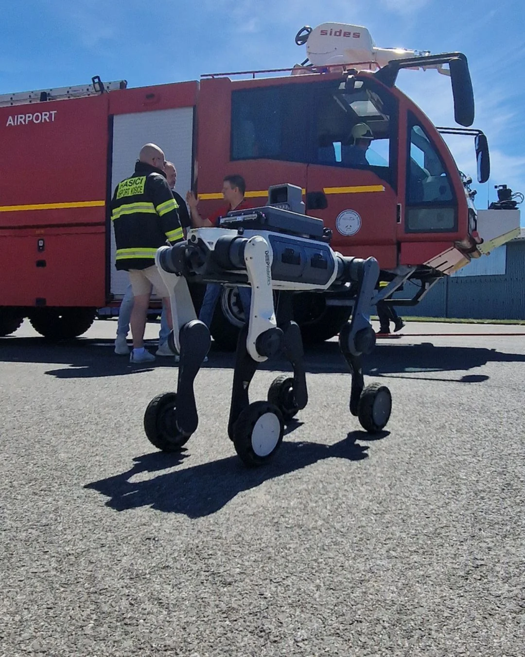 DEEP Robotics M20 Pro robot positioned beside an airport fire engine in Košice