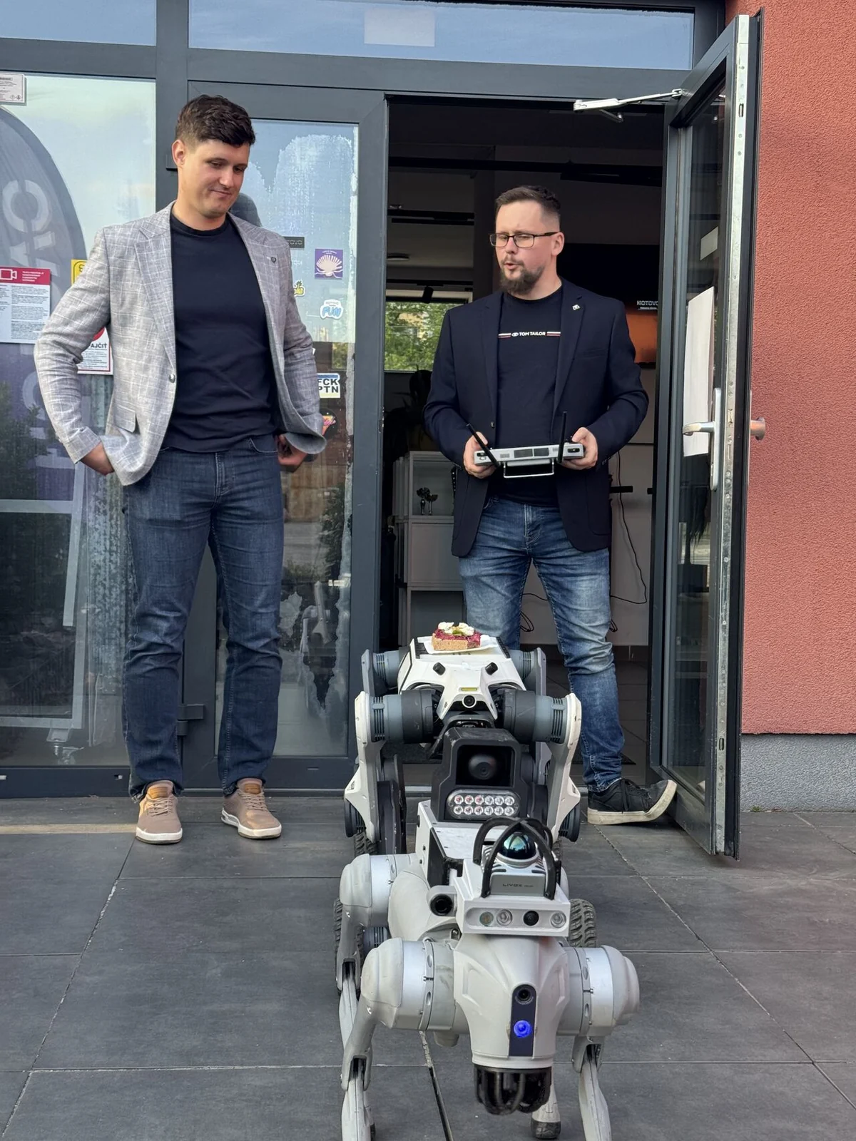 Invelogy team members with quadruped robot platforms outside the venue